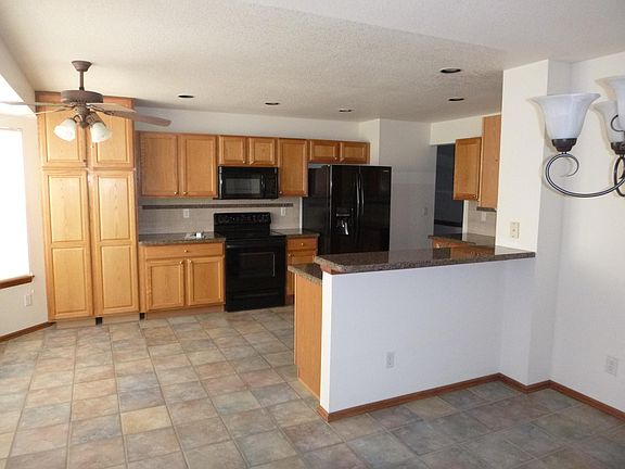 Kitchen with granite counter tops, tile floor, range dishwasher, refrigerator