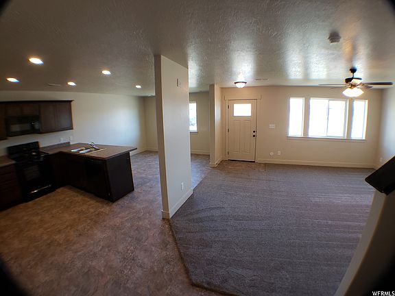 View of living room, kitchen, and dining room from the stairs looking to the front door.