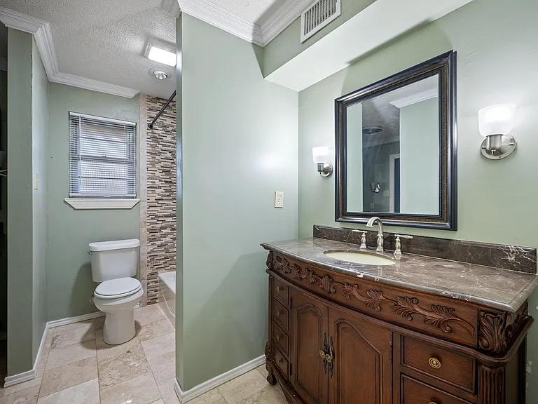 Full bathroom with a single-sink vanity, large framed mirror, and tiled shower surround for easy daily use.