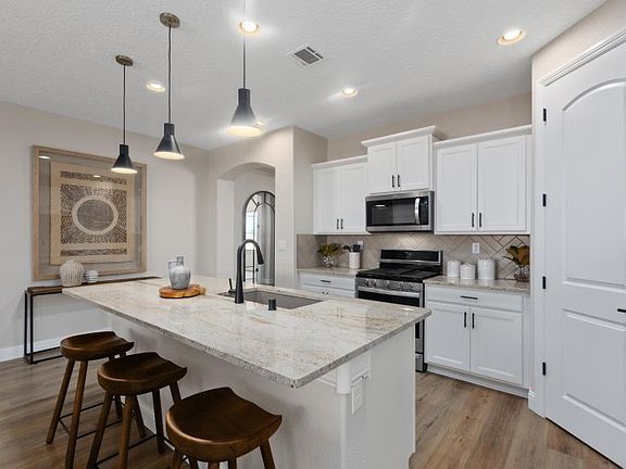 The Barlettta kitchen boasts functionality throughout with ample counter space, cabinetry, and a cor