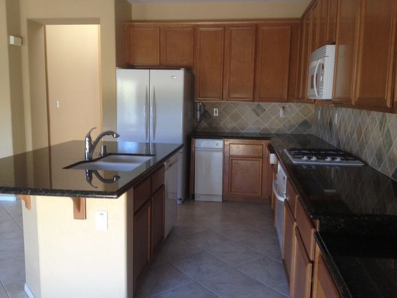 Tons of mocha maple cabinetry, nice appliances