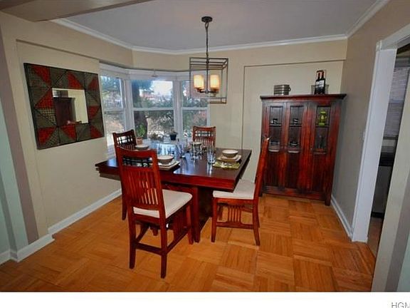 Dining room has a bay window, opens to the living room and refinished parquet floors. The room is 11