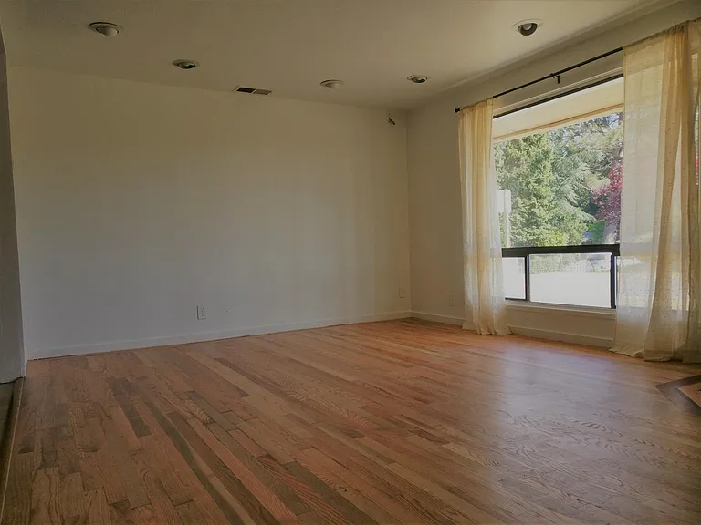 Beautiful large window in living room with refinished hardwo
