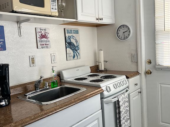 Kitchen equipped with stove, oven, microwave, full size refrigerator, toaster, coffee maker, rice cooker, dishes and utensils