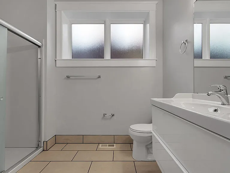 Bathroom - floating vanity, frosted glass by-pass shower doors, money-saving vent fan on a timer