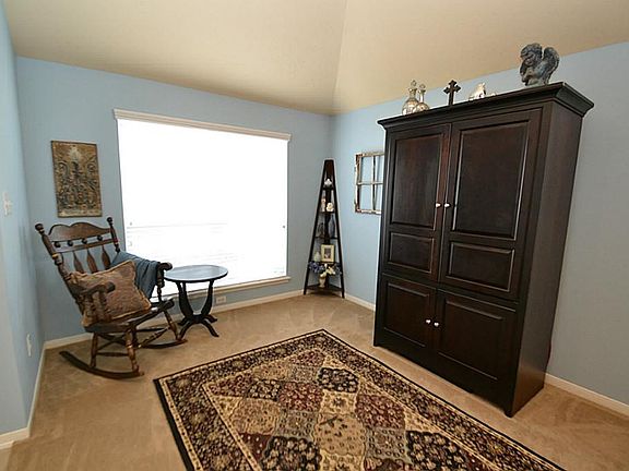 Living room accented by raised ceilings and opens to the dining room.