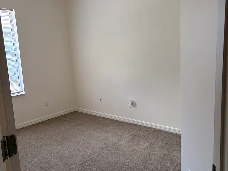 Bedroom 2 with ceiling fan and spacious closet. Bathroom just right outside bedroom.