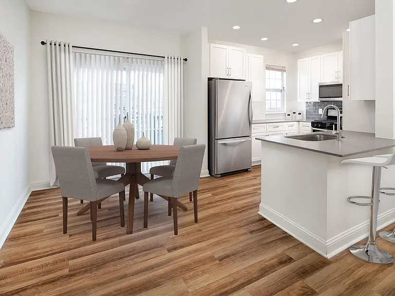 Kitchen and dining with white cabinetry, grey quartz countertops, grey tile backsplash, stainless steel appliances, and hard surface flooring