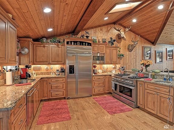 Dream kitchen! Custom cabinets, lazy susans, pull out spice rack and beautiful granite countertops w/ under mount sink & prep sink. Enjoy a bar/eating area, and top of the line GE Monogram appliances. Double oven with gas burners and grill.  Great can lighting PLUS opening skylight.  
