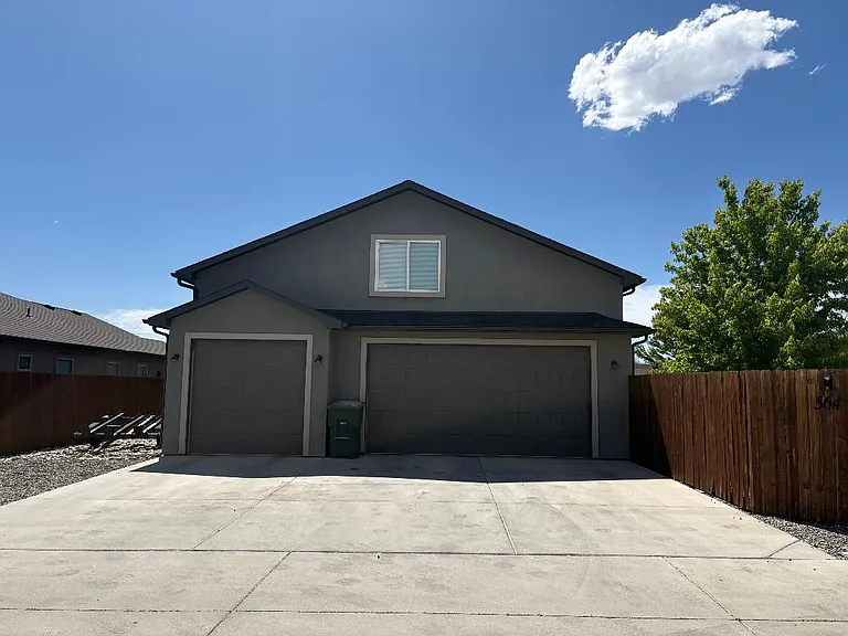 Back of house, 3 car garage, and extra car pad on the left
