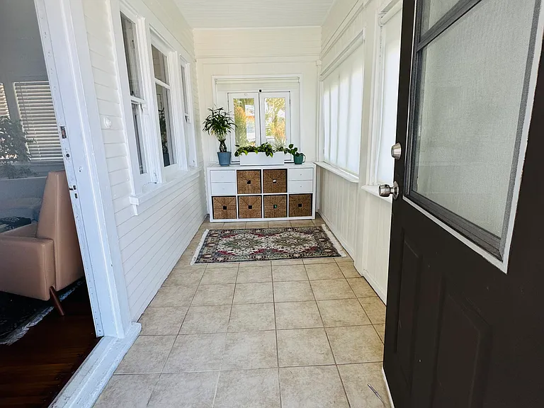 Tiled, enclosed porch/sun room.