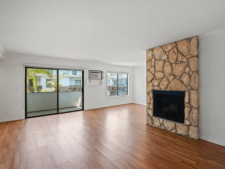 Living Room with and Electric Fireplace, Vinyl Flooring, Windows, and Patio