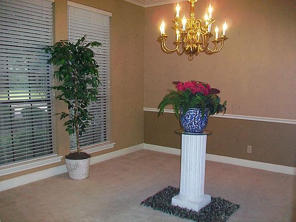 FORMAL DINING WITH CHANDELIER, & WINDOWS VIEWING THE FRONT GARDENS