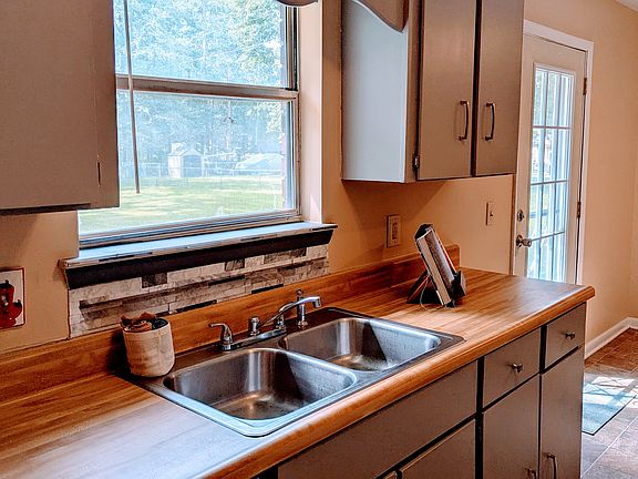 The Kitchen sink looks out the window to the backyard. The Glass door opens to a small patio area.