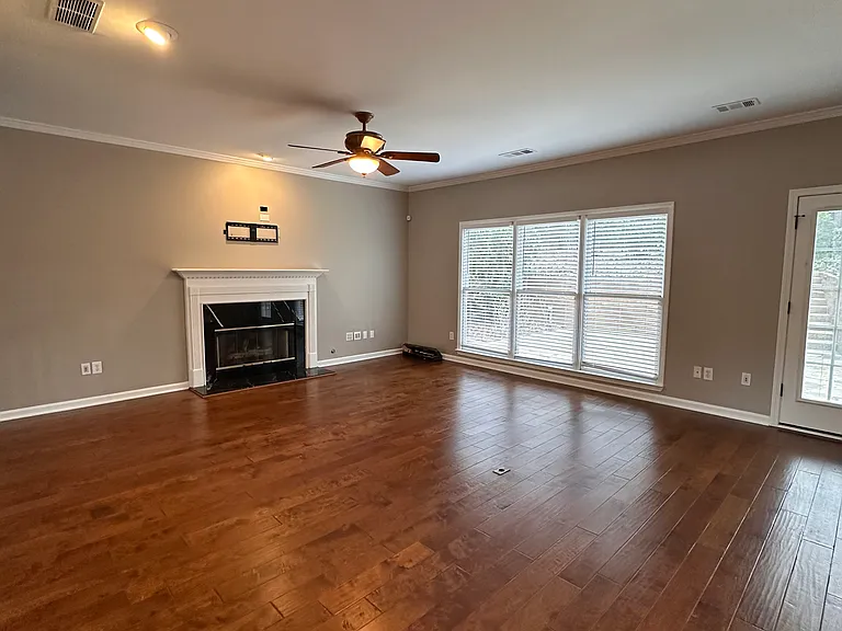 Large Family Room with fireplace and TV connections, looking over beautiful patio and private back yard.