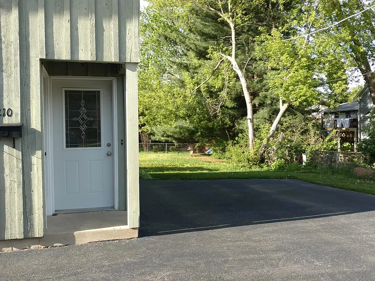 Entrance to apartment and two parking spots in the driveway to the right.