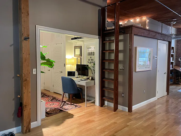 View from the entry way, of den and lofted storage area