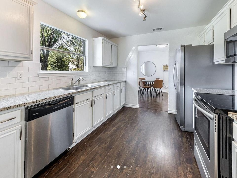 Galley kitchen with granite counters, ample cabinetry, and a full appliance suite, opening to the dining area.