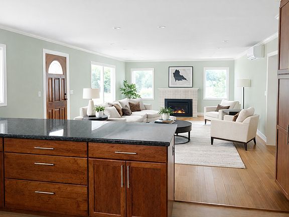 An open-concept kitchen flows seamlessly into the living area, where soft natural light and a fireplace create an inviting everyday retreat.