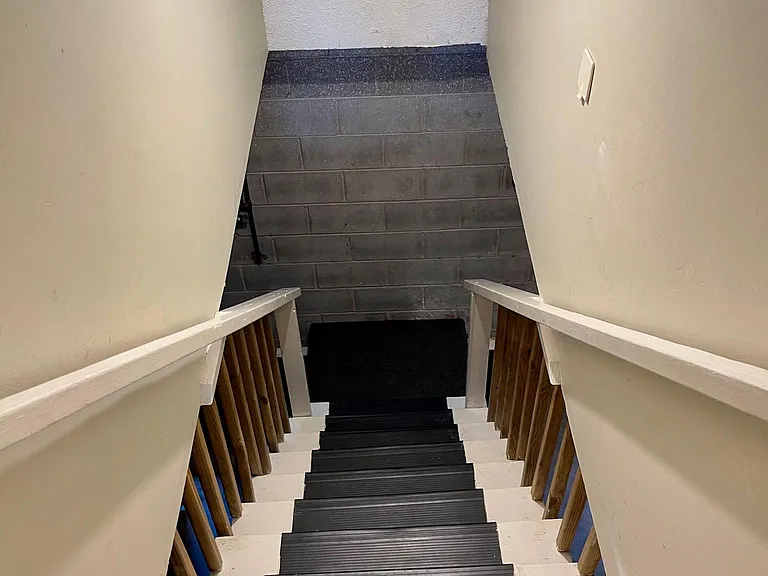 As you enter the garages you enter the house to the left of this staircase at the bottom. It is pretty much immediately where you enter the house from the garages. The right side of these stairs is the open storage space to use as you envision.