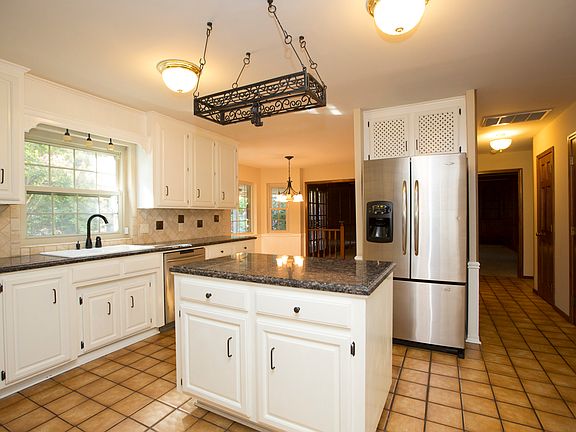 View from Kitchen into Breakfast Nook and Family Room reveals hall with large pantry, granite Powder Bath and deep coat closet.