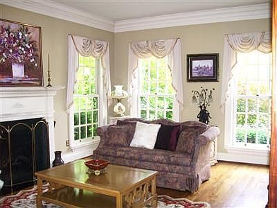 Formal Living Room Offers Gas Fireplace Tripple Crown Molding & Warm Hardwood 