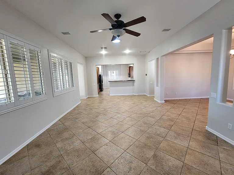 Living room toward kitchen. Back yard to the left.