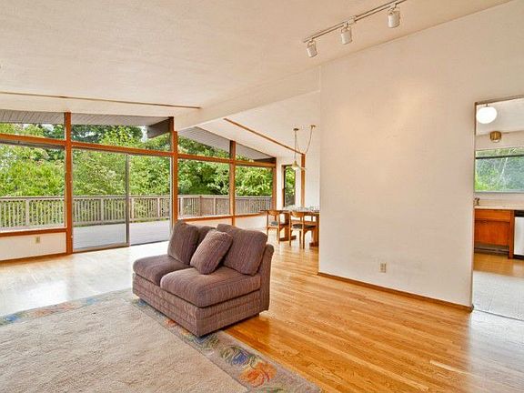 A great room floor plan! From here you can see the deck, dining room and the kitchen. Vaulted ceiling throughout the living room, dining room and kitchen.