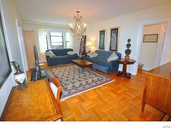 Oversized living room has parquet floors picture and wall moldings and overlooks tree lined Garth Ro