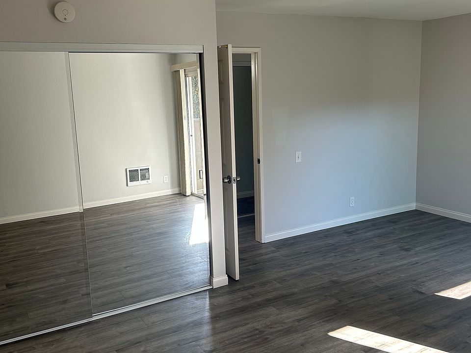Spacious bedroom with mirrored closet doors.