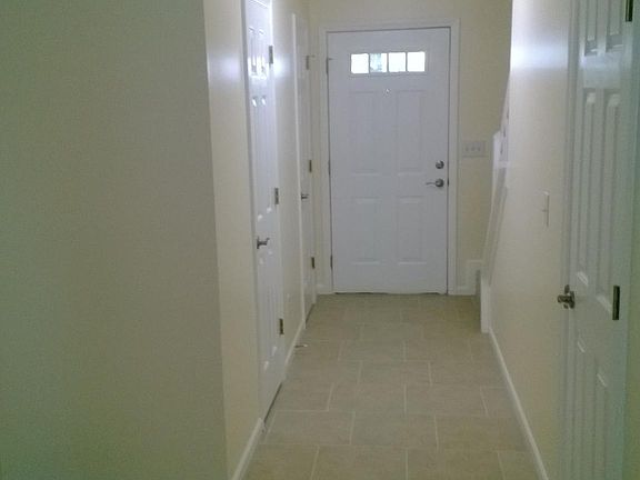 View from living room to front door with half bath and coat closet door on the left