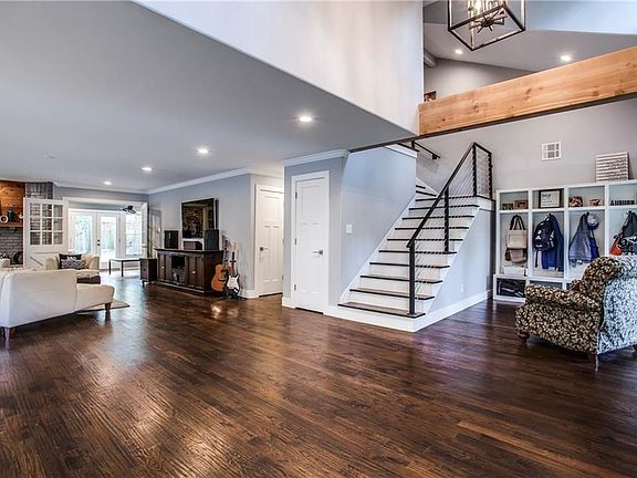 Breathtaking view of the living room, sun porch, and convenient locker storage providing a space for everything. Structural Beam & Metal banister are upscale architectural features.