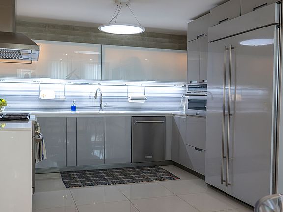 Sleek modern kitchen featuring high-end stainless steel appliances, custom cabinetry, and under-cabinet lighting. A chef's dream space blending function, elegance, and clean design.