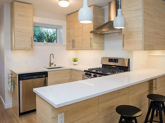 Kitchen with stainless steel dishwasher, gas range and breakfast bar