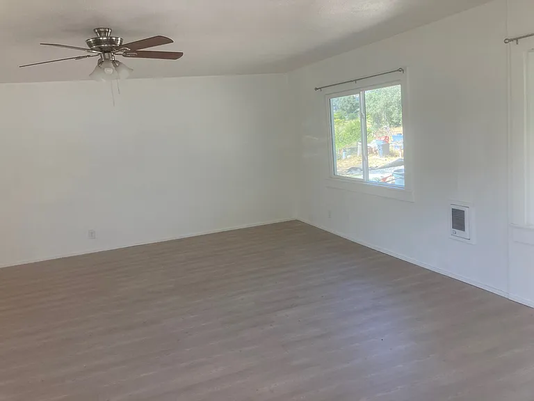View from the front door to the northeast of the large living room/dining room combination.
There are manually controlled exterior security lights on the exterior of this wall to light up the driveway as well as a set of motion sensor security lights