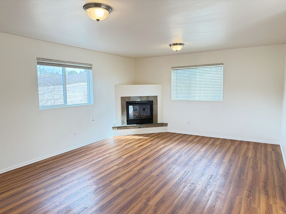 Large living room with laminate flooring, gas fireplace, and views of the rabbit preserve.