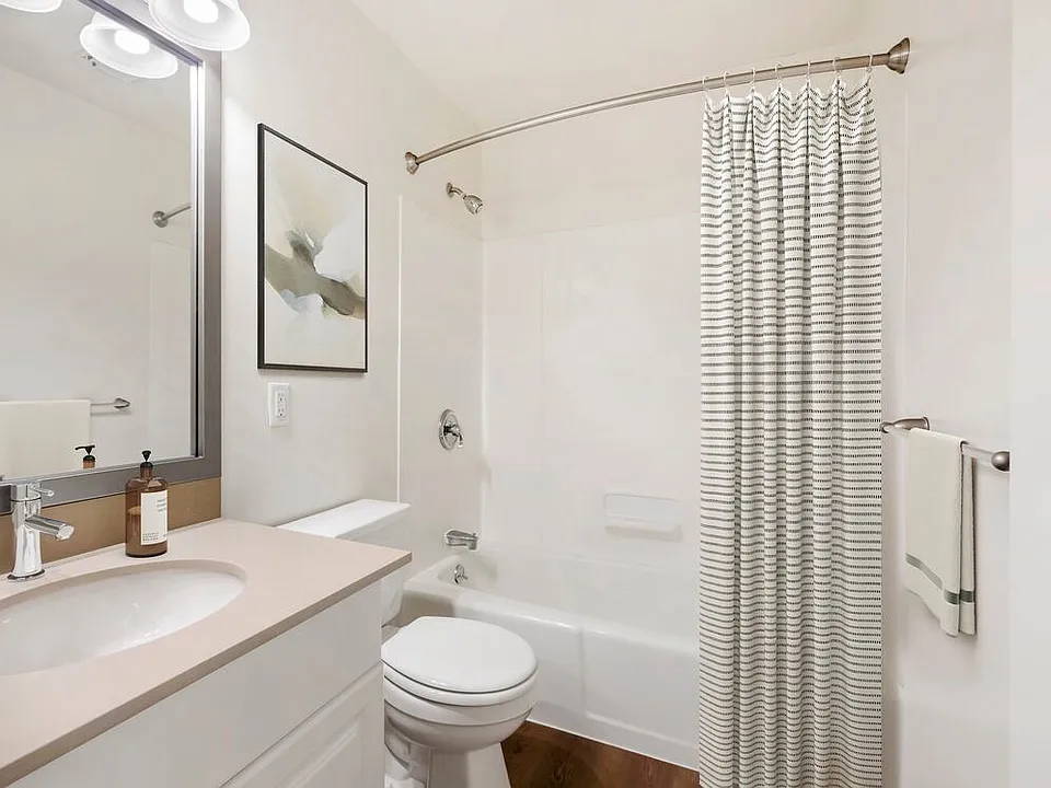 Renovated Package III bath with grey quartz countertops, white or cherry cabinetry, and hard surface flooring