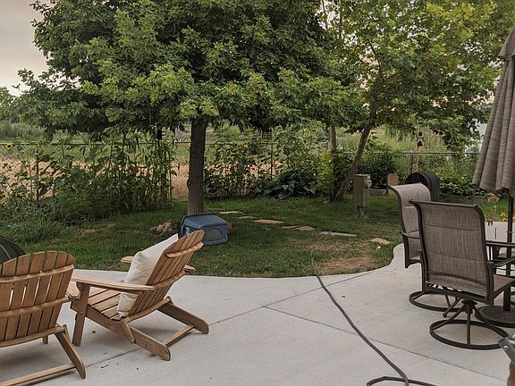 Spacious back patio, fenced yard, and multiple raised garden beds - watch wildlife from the comfort of home!