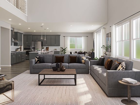 A spacious and modern living room with a large gray sectional sofa, a wooden coffee table, and a kit