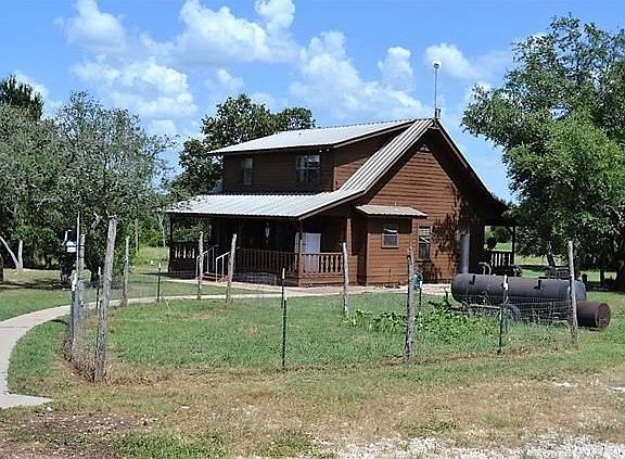 View of the back of the home - and another large porch. Entry into the dining area as well as the utility room from this porch.
