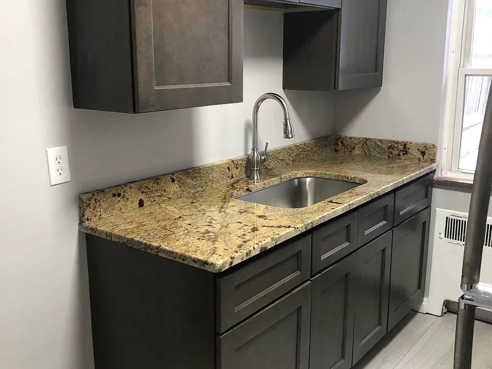 New kitchen cabinets, granite counter, sink, faucet, and flooring.