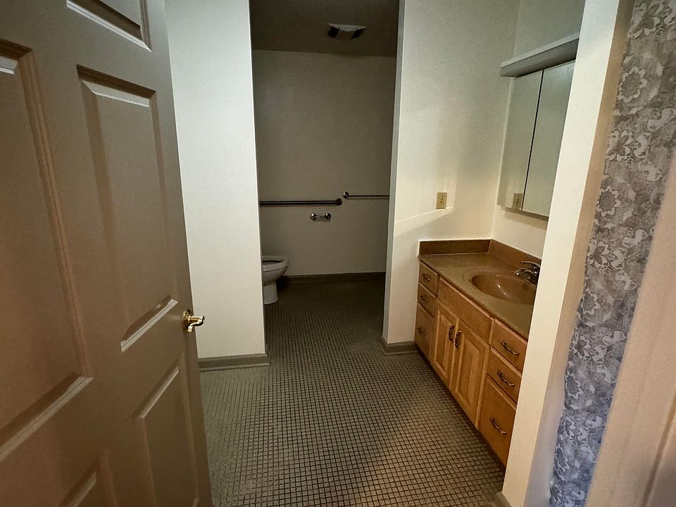 Bathroom with tile floors, mirror, sink with cabinets