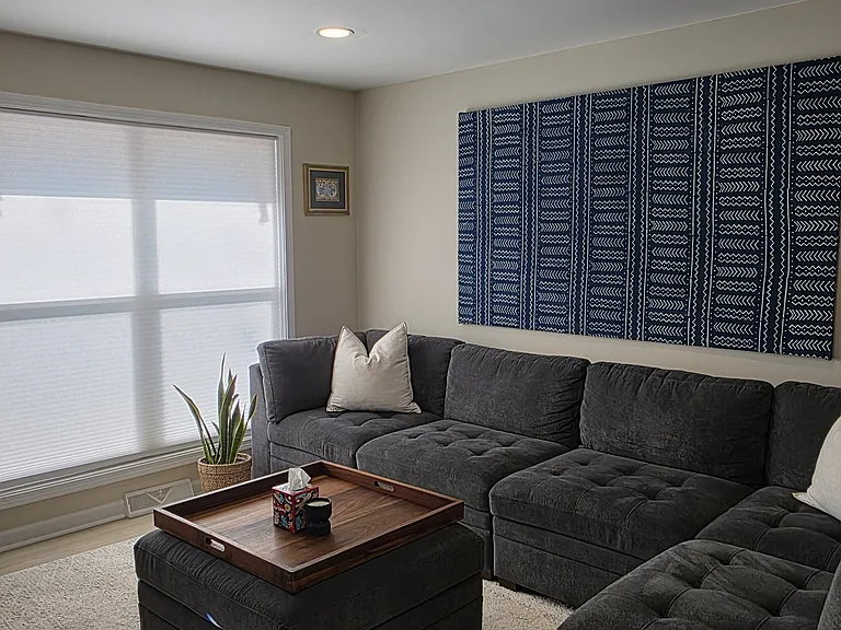 The living area has a large window for plenty of natural light and cordless shades for privacy.