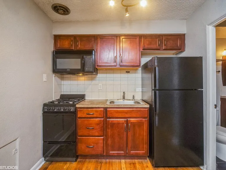 Rich wood cabinetry and tiled backsplash in the kitchen