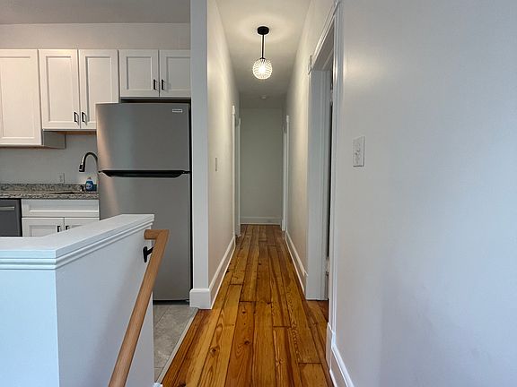 Hallway leading to kitchen, bedroom/den, bathroom and living room.