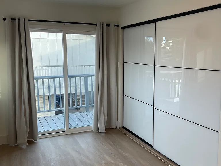 Bedroom Room-1 Bedrooms with new windows, custom blinds, modern sliding closets featuring glossy white and mirrored glass doors, and direct access to a private balcony