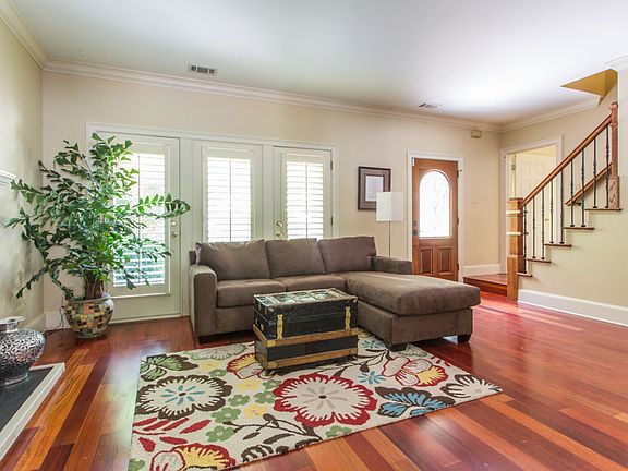 Spacious living room with hardwood floors and plantation shutters
