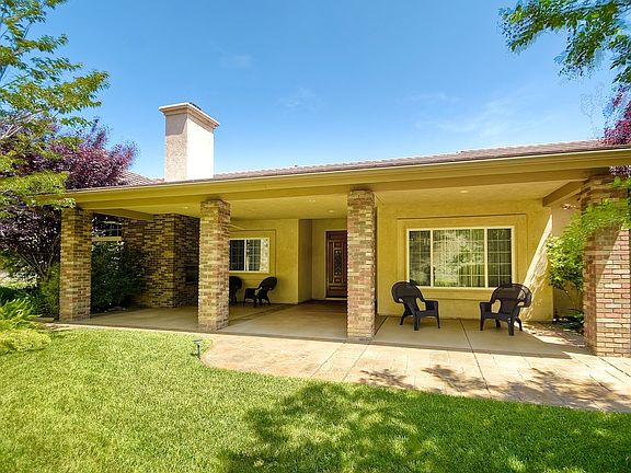 Front patio with fireplace and ceiling fan.