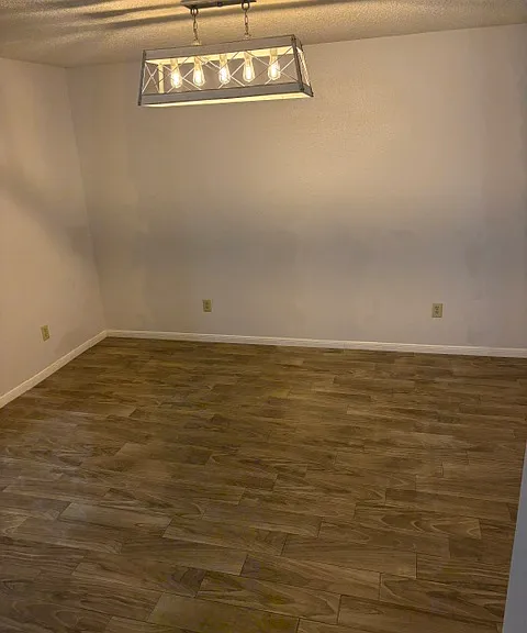 Spacious Dining room with new light fixture and tiled floors.