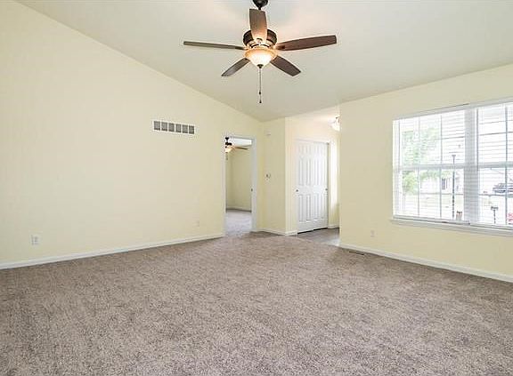 Living room showing view of the front of the home.  Updated ceiling fan with light kit.